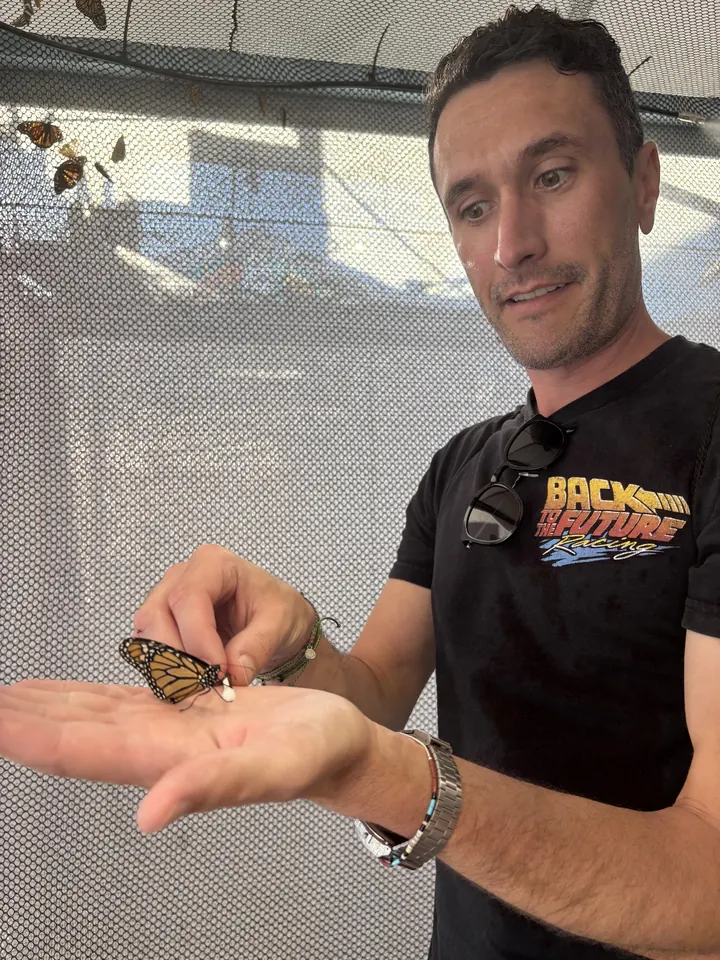 Robbie with an orange butterfly resting on his hand