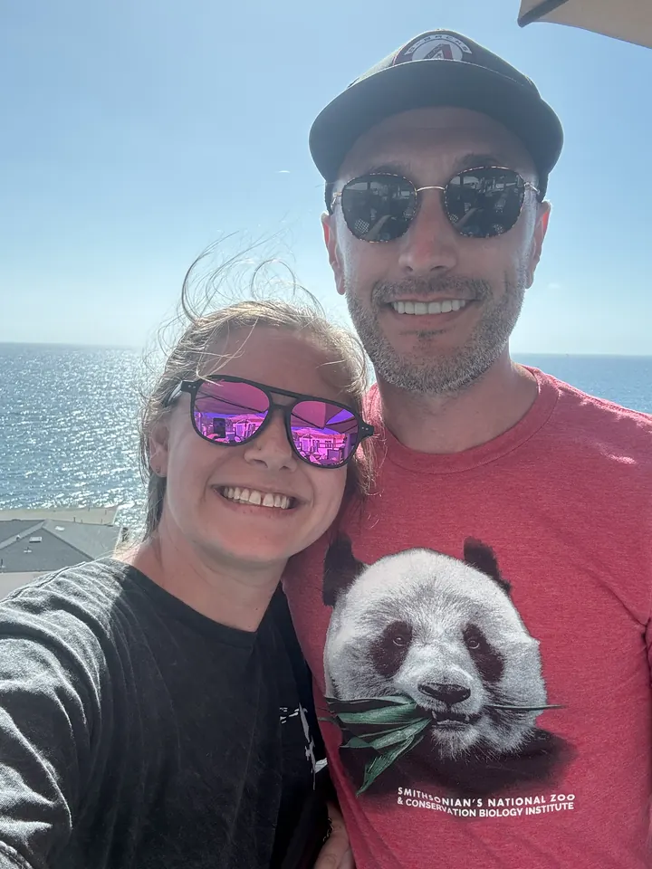 Robbie and a friend in sunglasses taking a selfie by the ocean